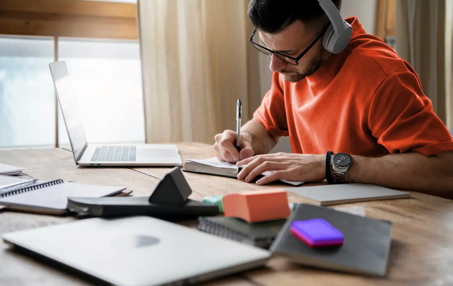 Focused man studying at desk with books and laptop, symbolizing learning, education, and online knowledge growth.