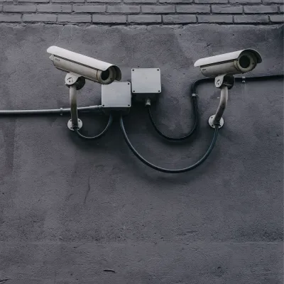 Two security cameras mounted on a gray wall