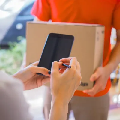Person signing a digital package delivery on a smartphone