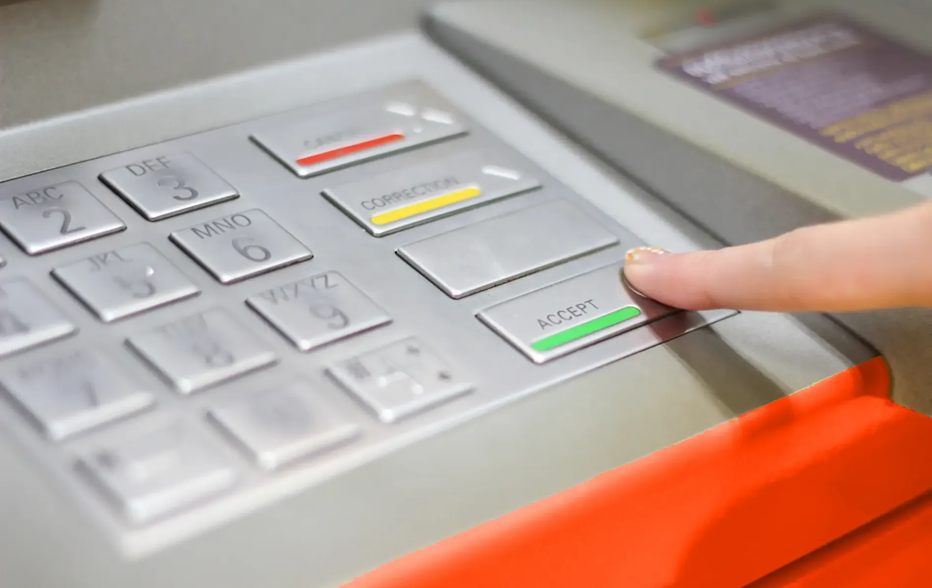 Person hebt Geld am Geldautomaten ab