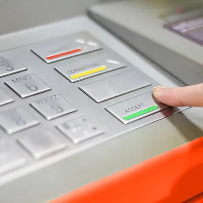 Person hebt Geld am Geldautomaten ab