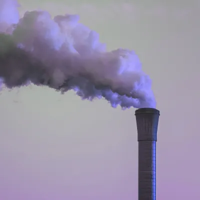 Smokestack emitting a large cloud of industrial exhaust into the sky