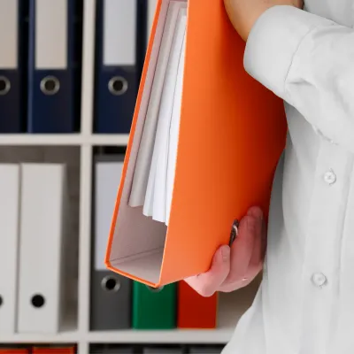 Person holding an orange document folder