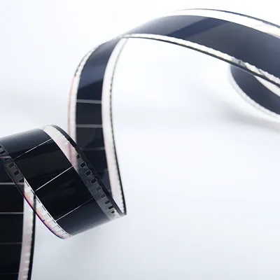 Close-up of a black translucent film strip in a curved shape on a bright background