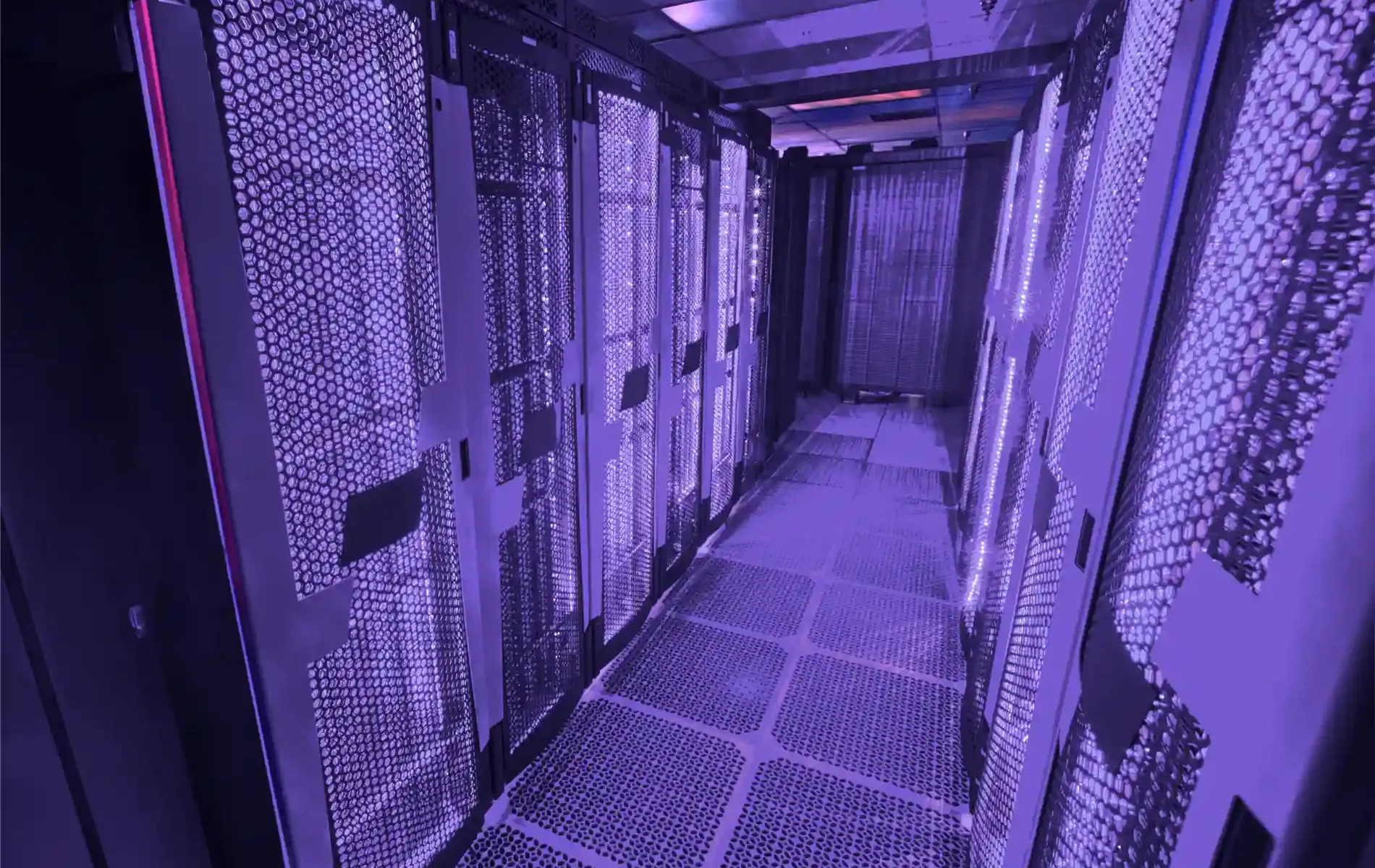 Moderner Serverraum mit beleuchteten Rack-Reihen und violettem Licht.