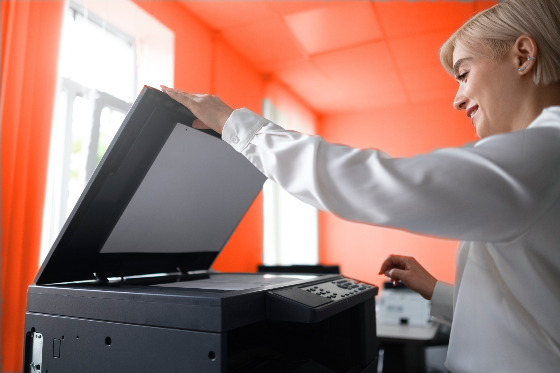 Mitarbeiterin digitalisiert Unterlagen mithilfe eines Scanners im Büro.