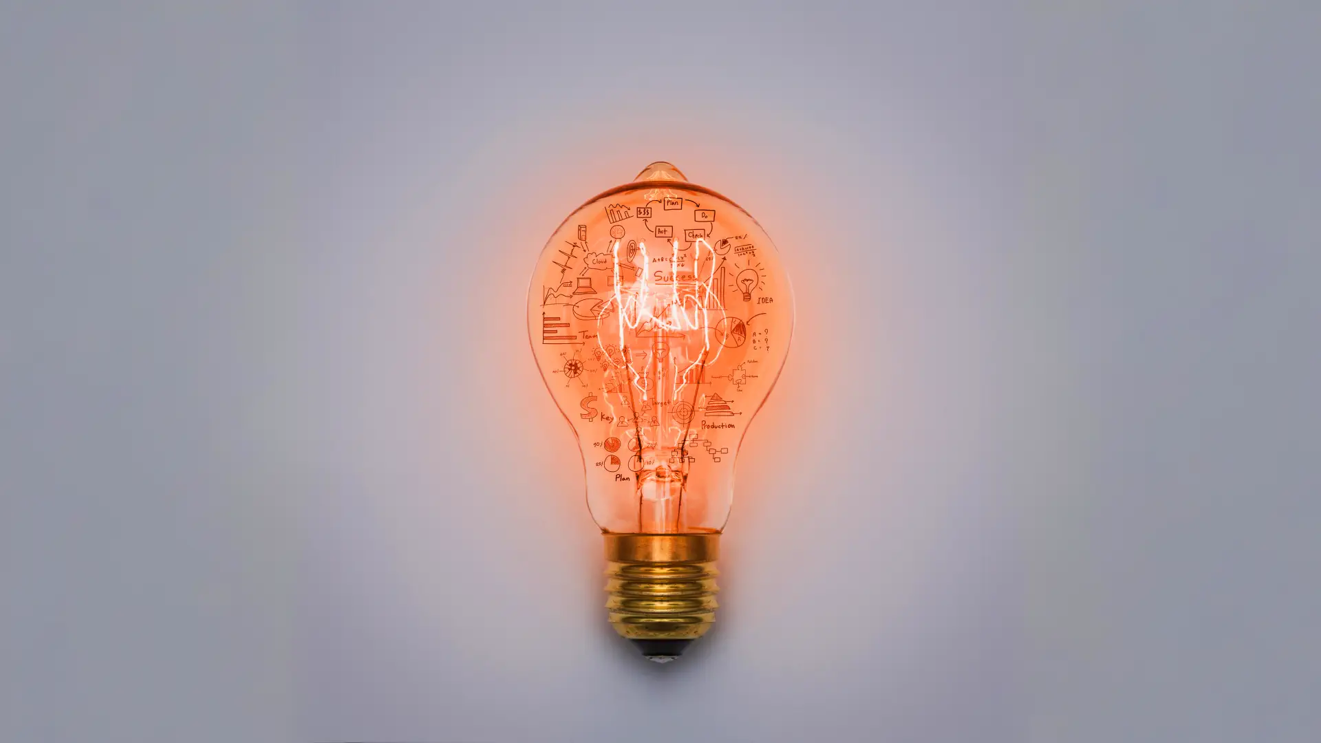 Eine orange glühende Glühbirne mit Wissen auf dem Glas.