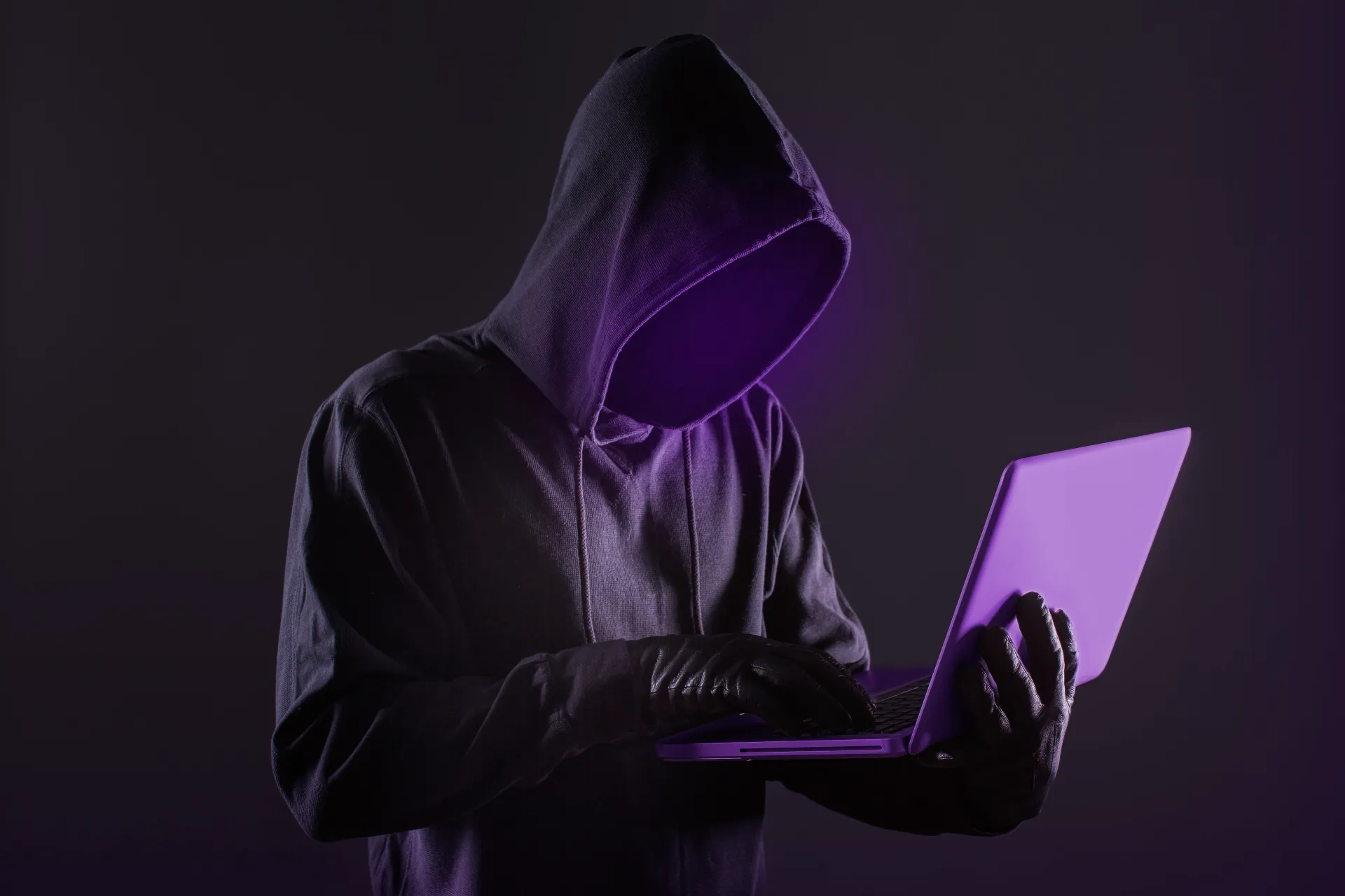 Hacker mit Laptop in der Hand.