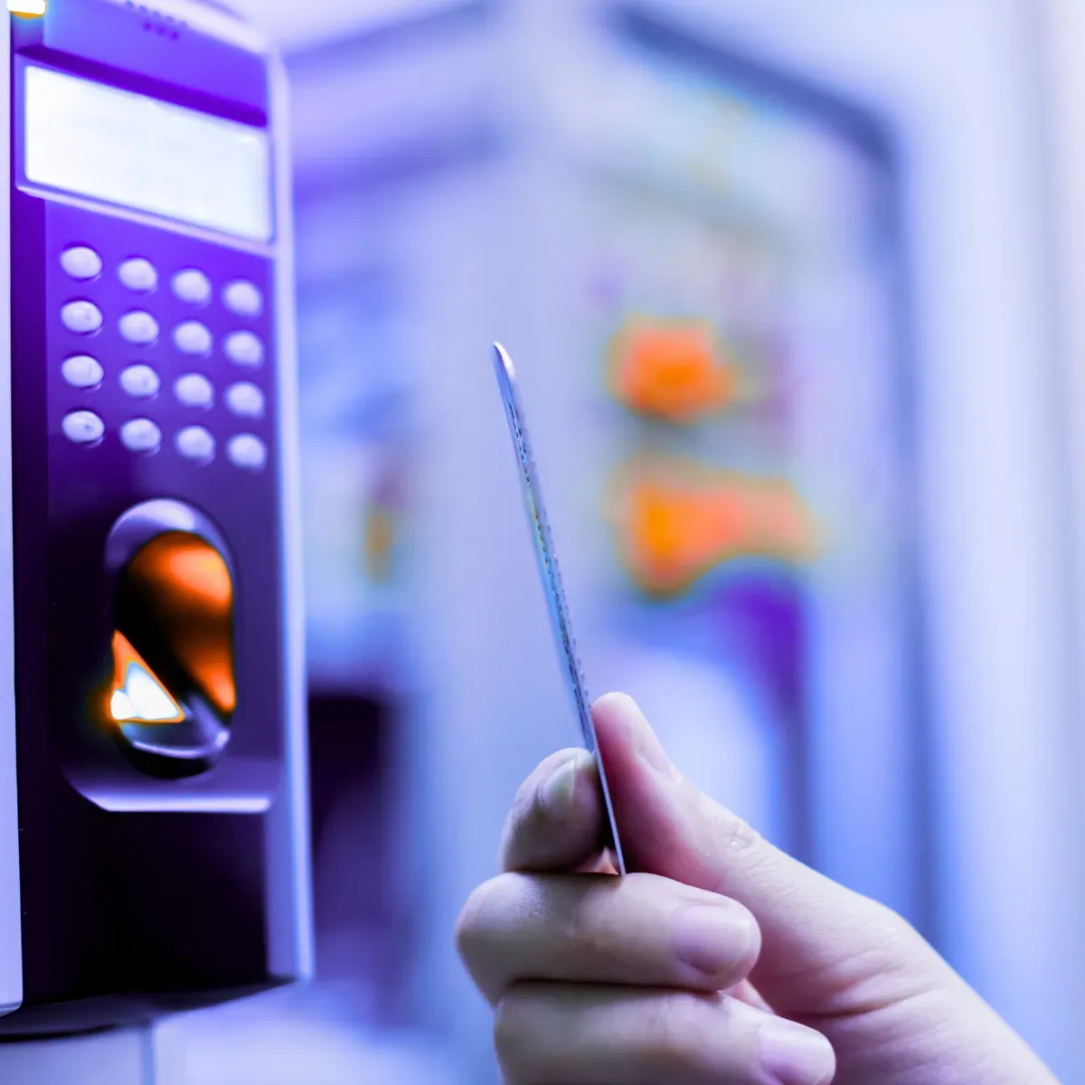 Person hält eine Zugangskarte vor ein elektronisches Zutrittslesegerät.