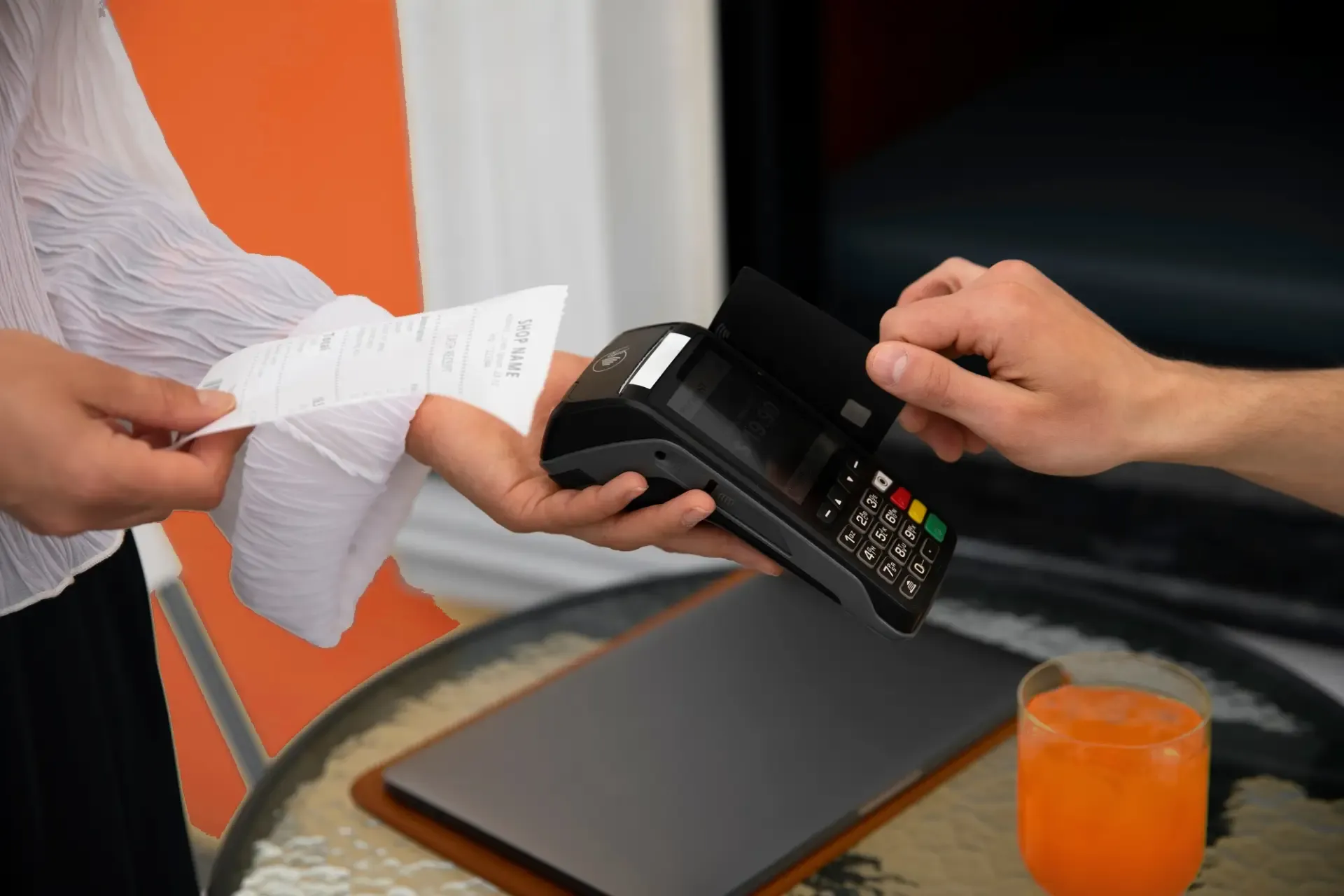A person taps a credit card on a payment terminal.