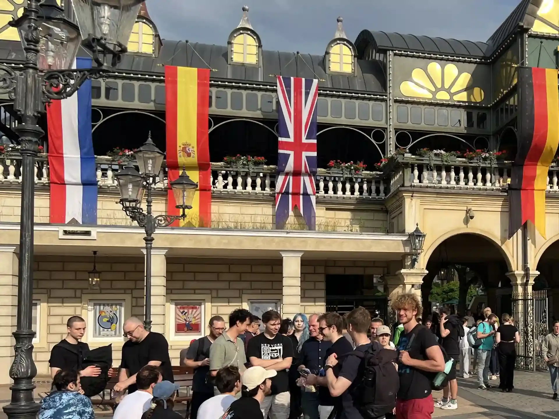 People gather before a building decorated with European flags.