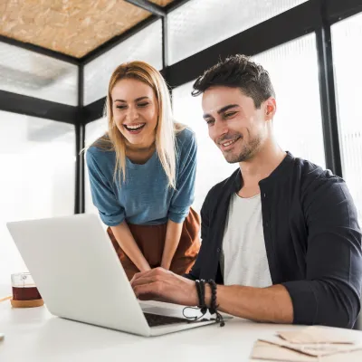Happy coworkers in front of a laptop in the office