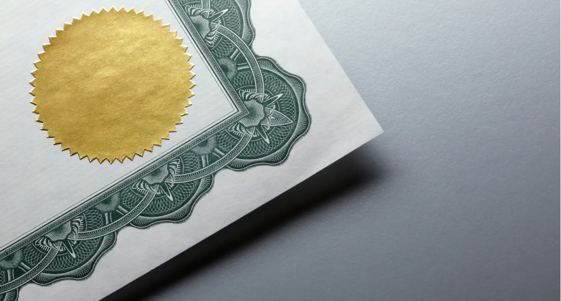 Corner of a certificate with a gold seal and green border.