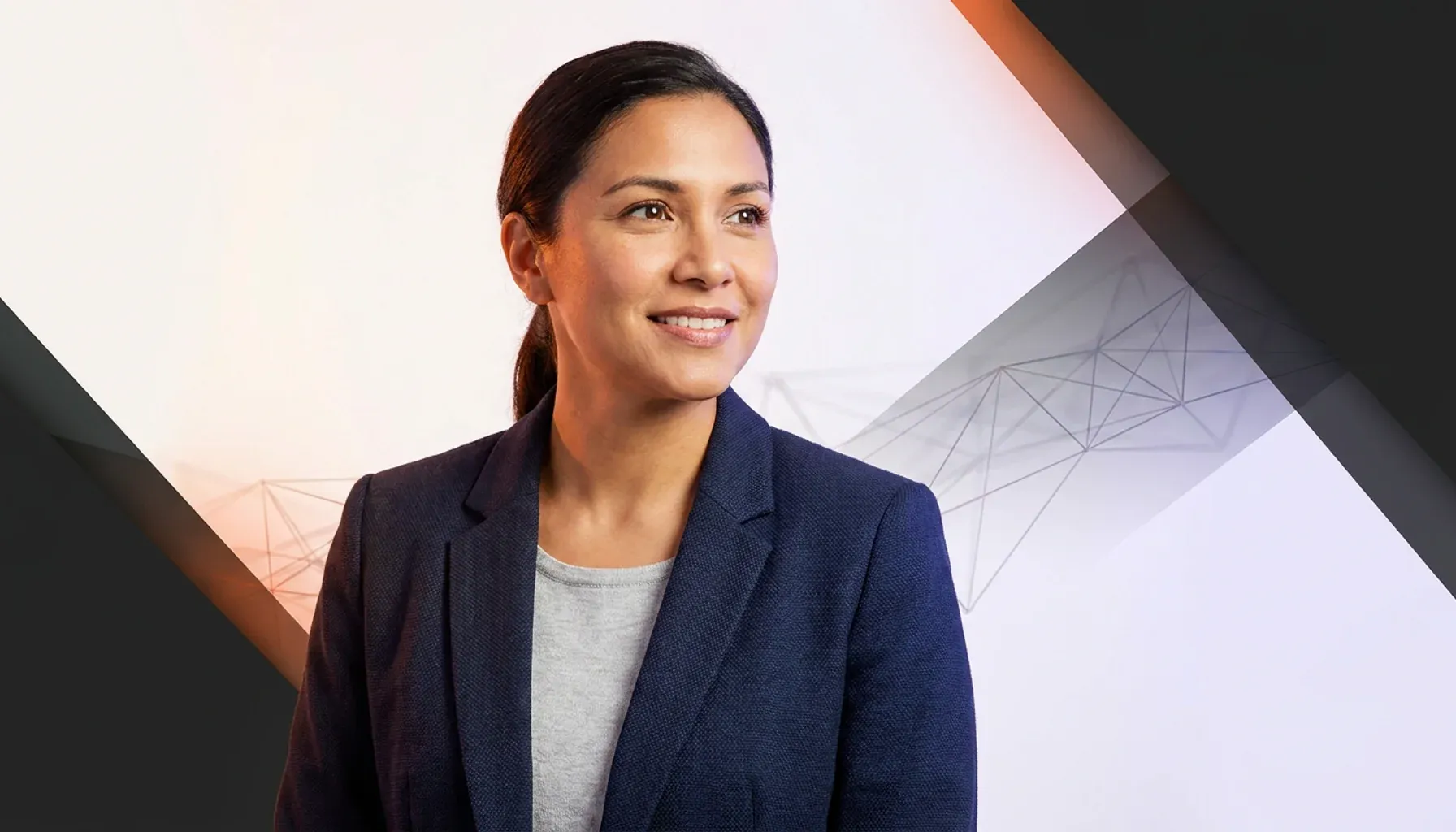 Smiling businesswoman in a navy blazer looking away against a modern geometric background.