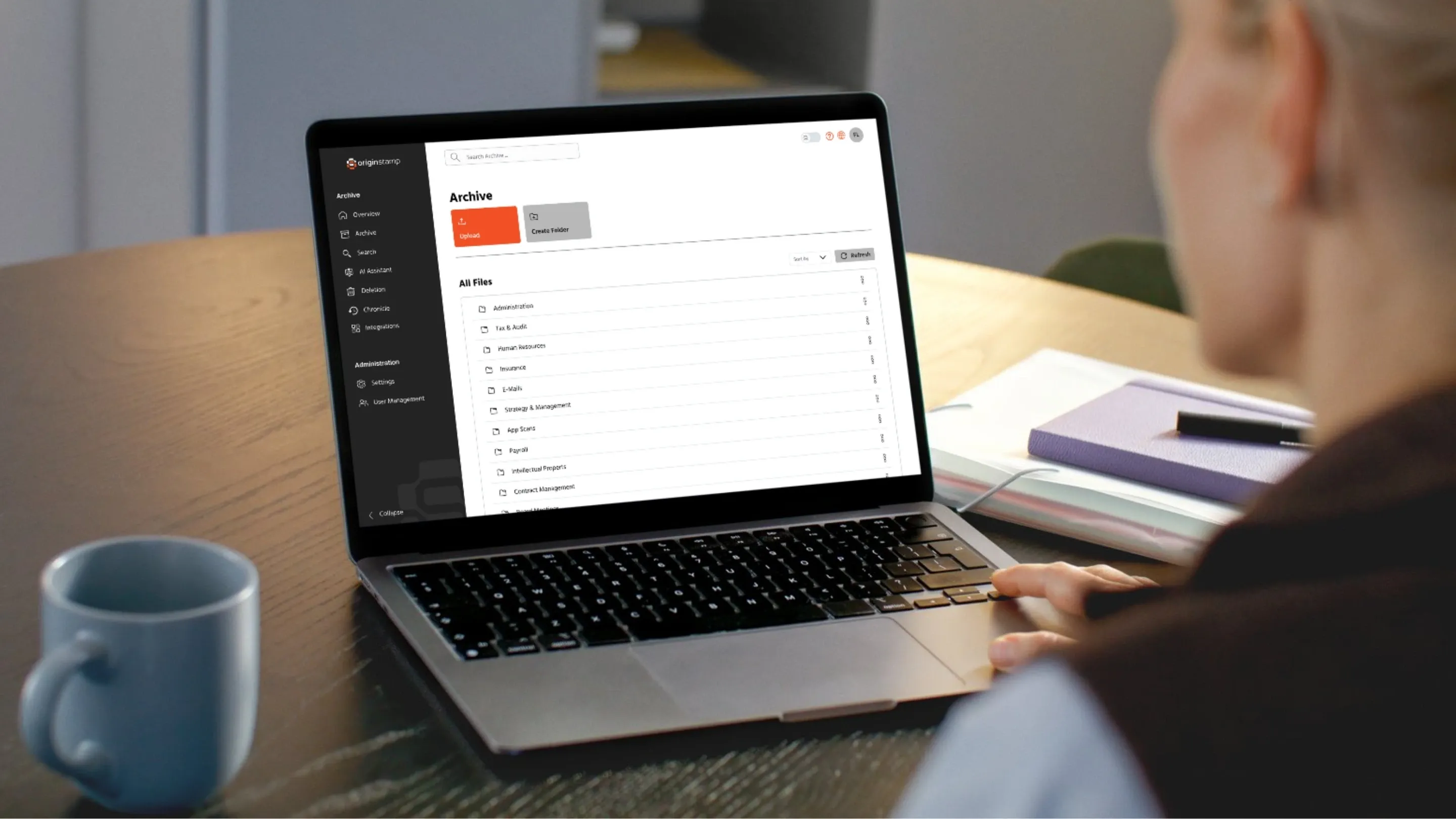 Eine Person navigiert die OriginStamp-Archivsoftware auf einem Laptop.